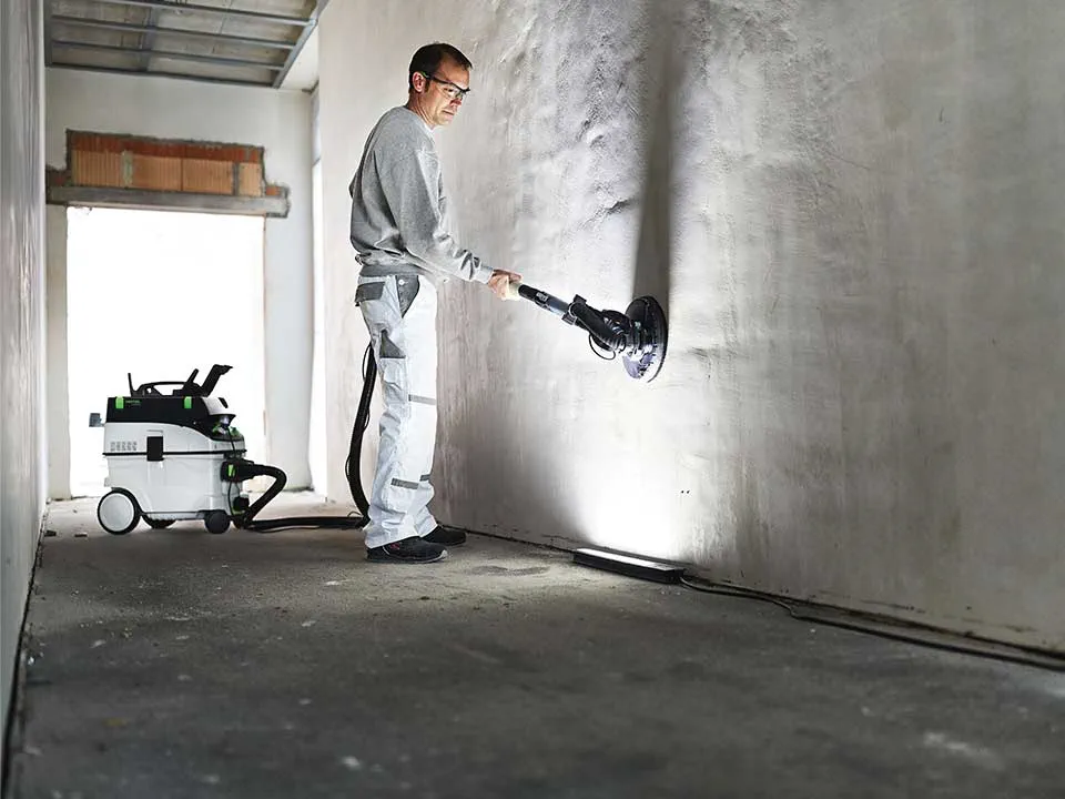 Meistras apšviečia sieną, pasitelkdamas tapytojo šviesos juostą, ir ją nušlifuoja.